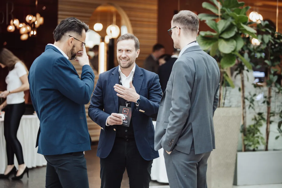 Networking tří účastníků ve foyer, Trendy Leaders